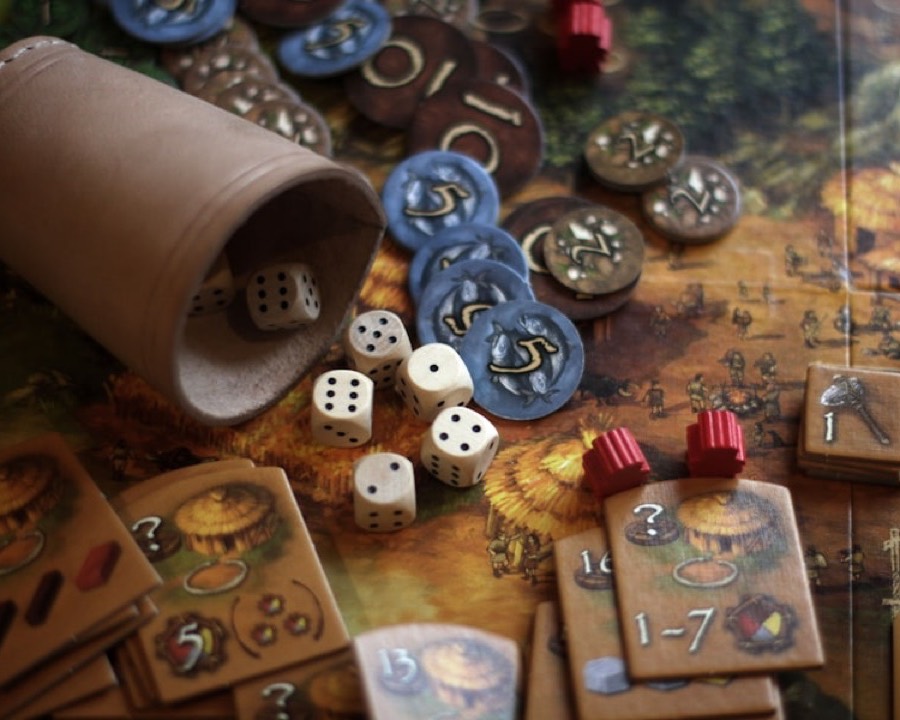 Dice, cards and tokens spread across a board game