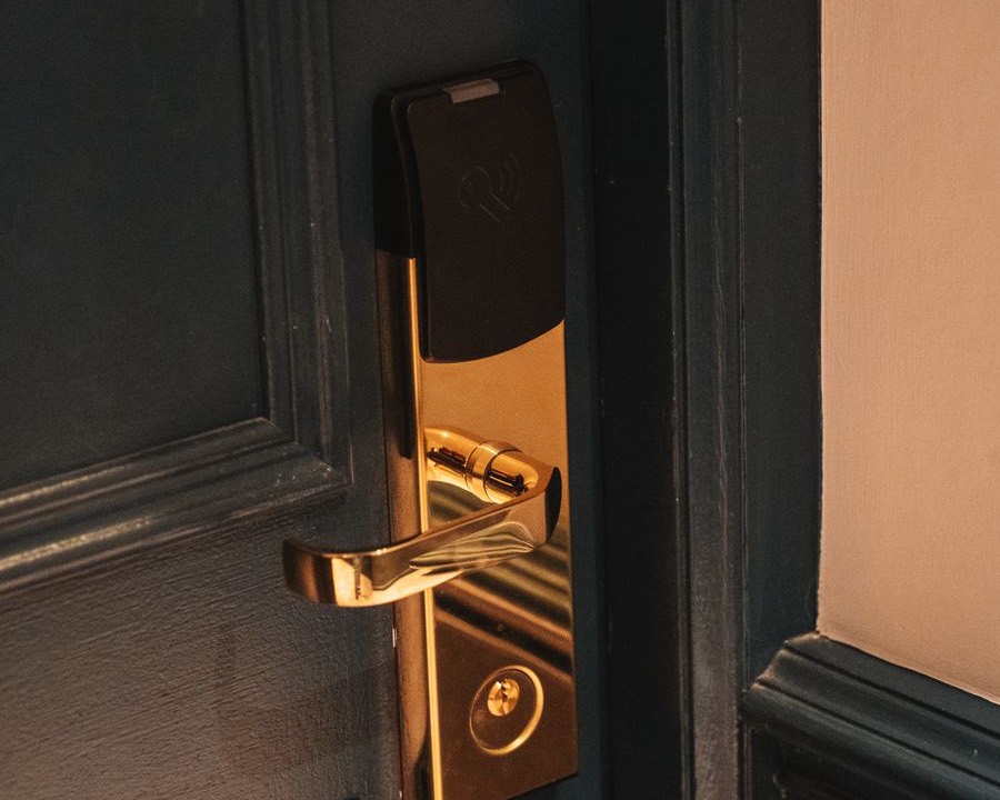 A brass keyless entry lock on a dark panelled door